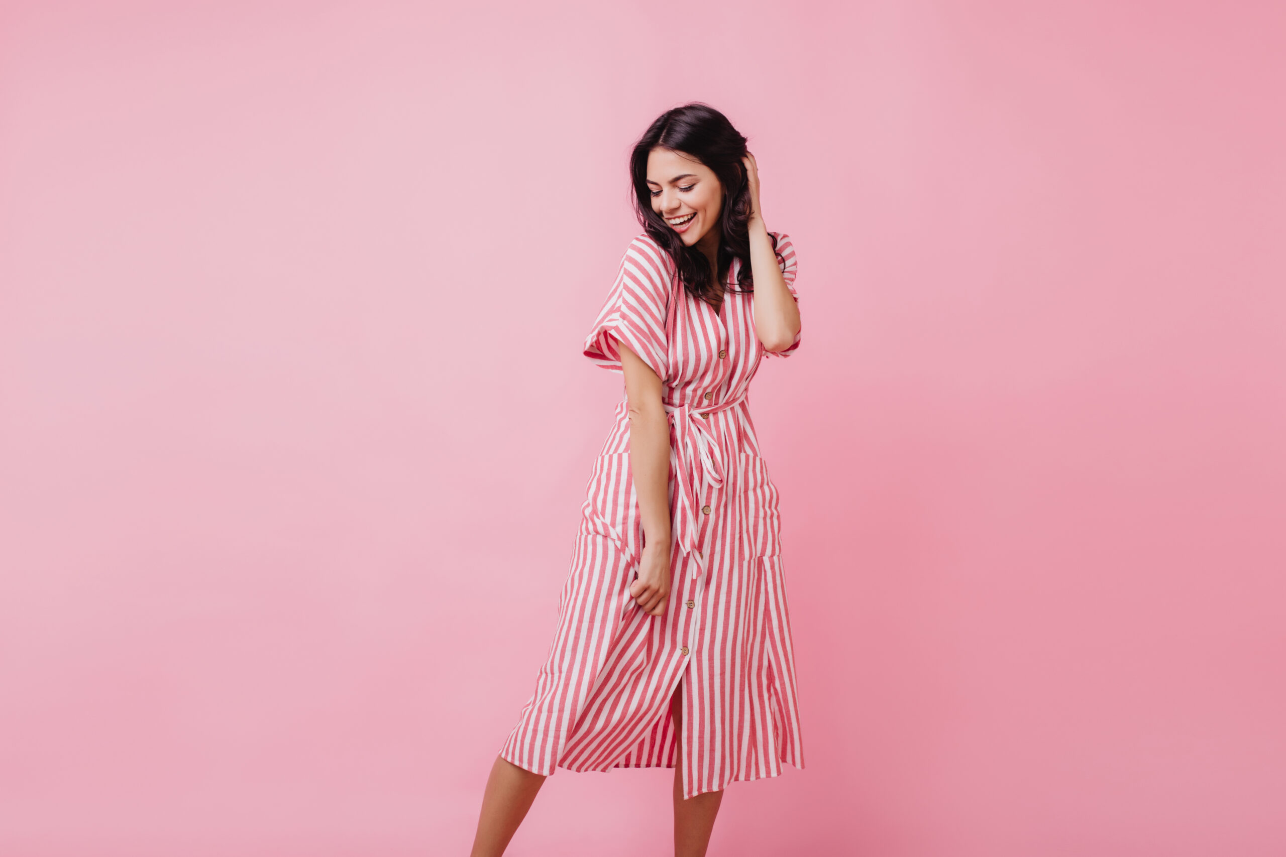 Romantic slim woman with brown hair dancing with inspired smile. Pretty caucasian girl posing in studio in summer day